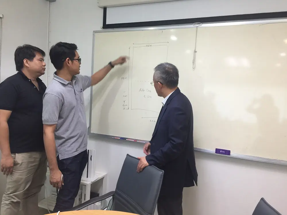 Discussing the machine layout plan with customers in Thailand.
